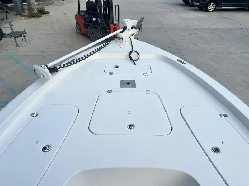 Slide: The Image of 2022 Sea Hunt BX 25 BR boat deck with trolling motor, parked on concrete surface. - 17