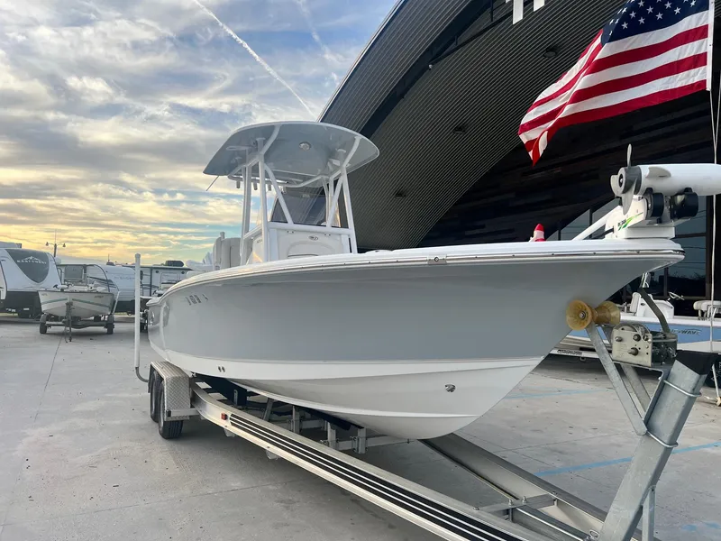 Slide: The Image of 2022 Sea Hunt BX 25 BR boat on trailer, American flag, cloudy sky background. - 2