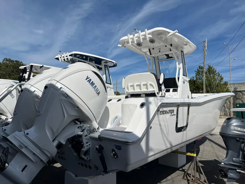 Slide: The Image of 2024 Tidewater 256 CC Adventure boat with Yamaha engine, parked outdoors under blue sky. - 3
