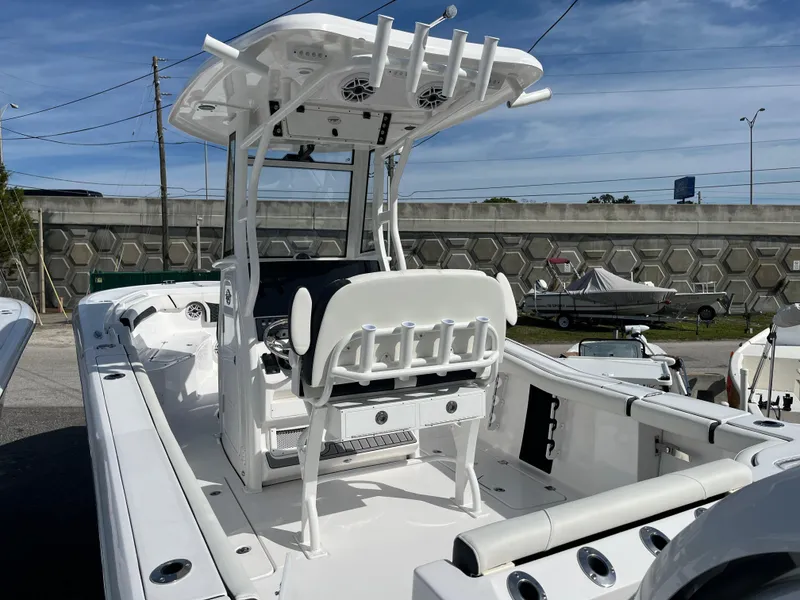 Slide: The Image of 2024 Tidewater 256 CC Adventure boat with T-top and seating, docked outdoors. - 5