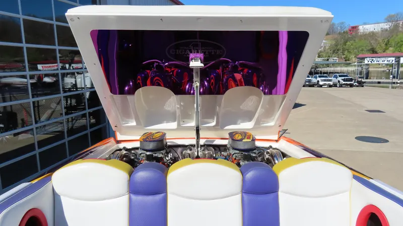Slide: The Image of 2003 Cigarette 38 Top Gun boat with open engine compartment, vibrant seating, and reflective surfaces. - 14
