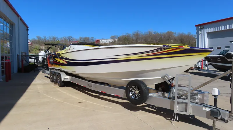 Slide: The Image of 2003 Cigarette 38 Top Gun speedboat on trailer, vibrant graphics, parked outdoors. - 15