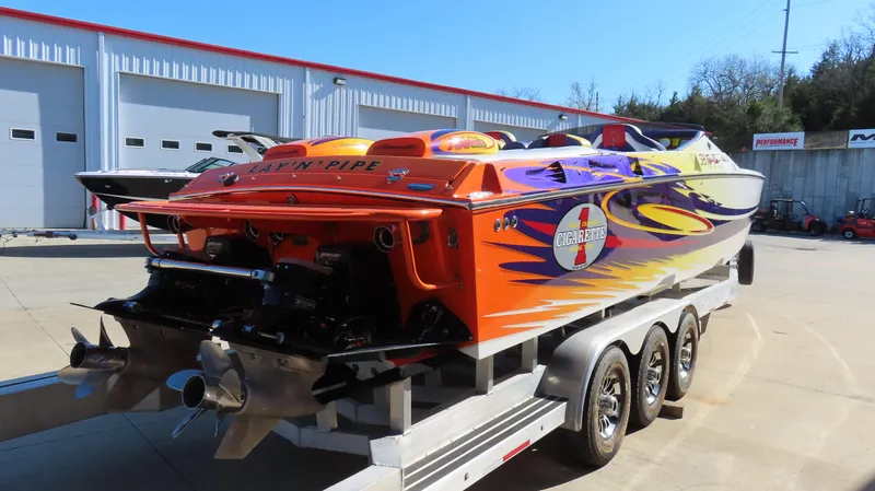 Slide: The Image of 2003 Cigarette 38 Top Gun speedboat with vibrant custom paint on a trailer. - 16