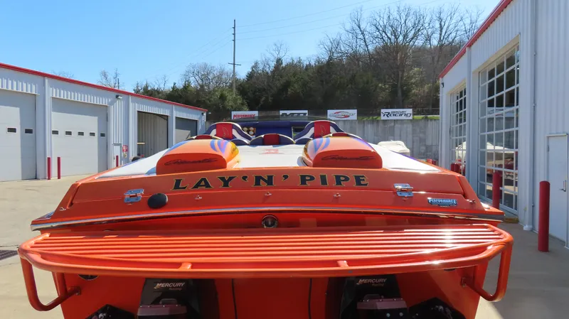 Slide: The Image of 2003 Cigarette 38 Top Gun speedboat with vibrant orange design at a marina. - 18