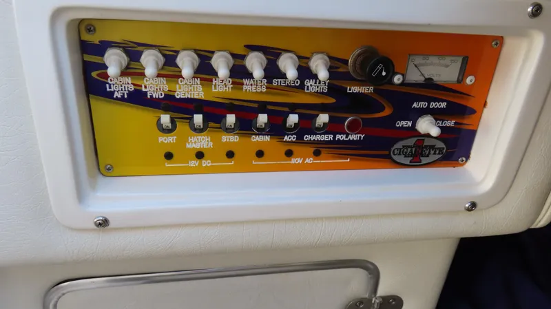 Slide: The Image of Control panel of a 2003 Cigarette 38 Top Gun boat with various switches and gauges. - 24