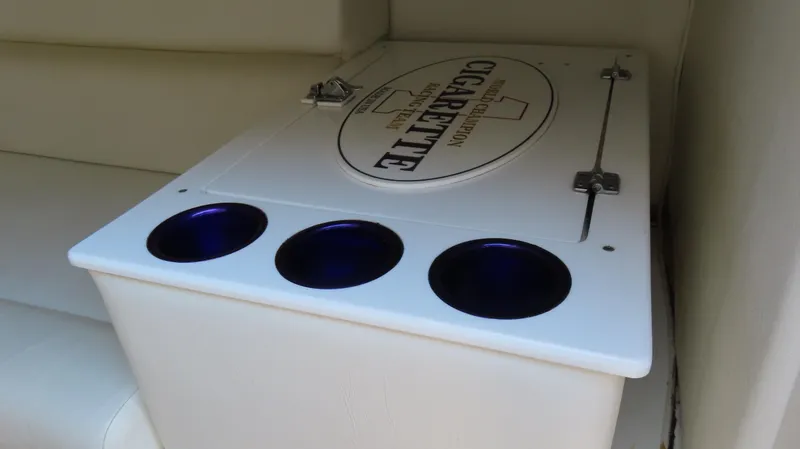 Slide: The Image of 2003 Cigarette 38 Top Gun boat interior with cup holders and branded storage compartment. - 28