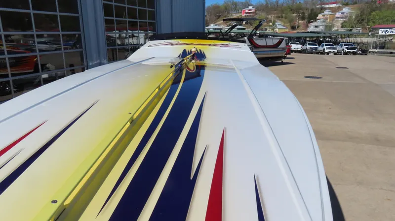 Slide: The Image of 2003 Cigarette 38 Top Gun boat with vibrant yellow, blue, and red graphics. - 8