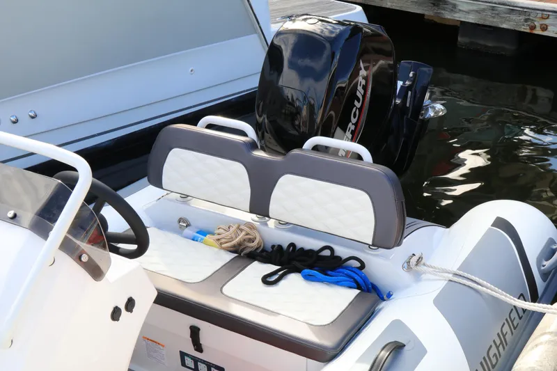 Slide: The Image of 2023 Highfield SP390 boat interior with seating, ropes, and Mercury engine. - 13