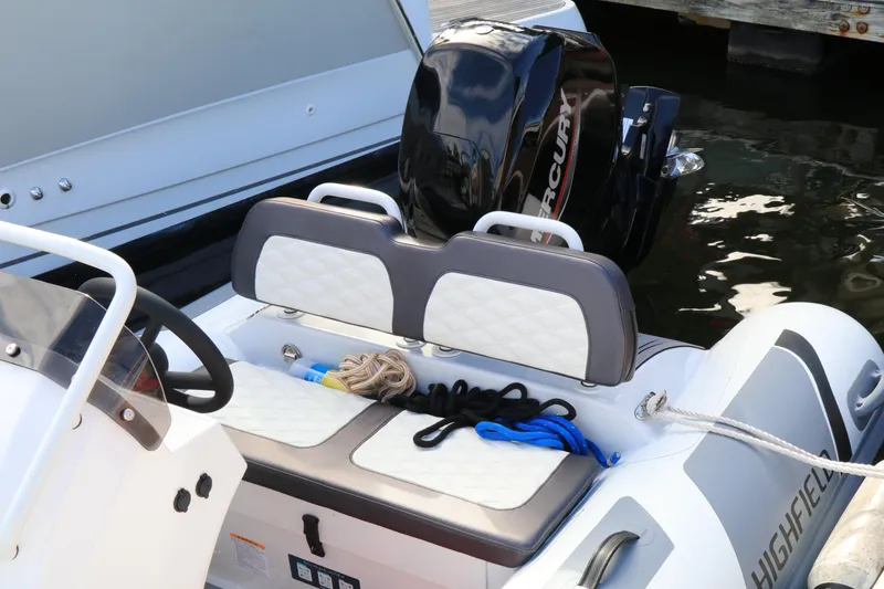 Slide: The Image of 2023 Highfield SP390 boat with Mercury engine, featuring dual seats and nautical ropes. - 14