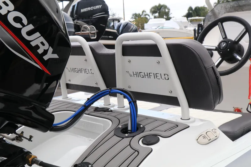 Slide: The Image of 2023 Highfield SP390 boat interior with Mercury engine, featuring seating and steering wheel. - 15