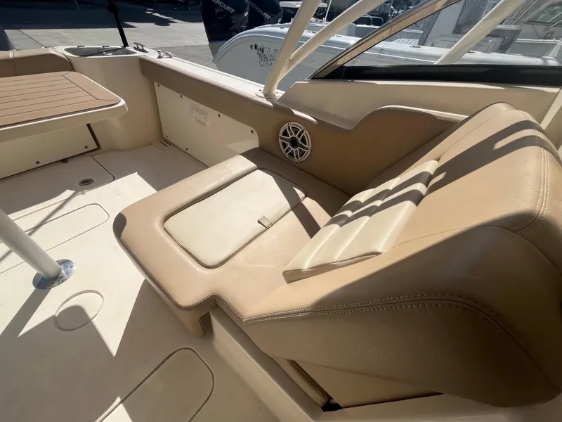 Slide: The Image of 2023 Scout 255 Dorado boat interior with beige seating and table. - 11