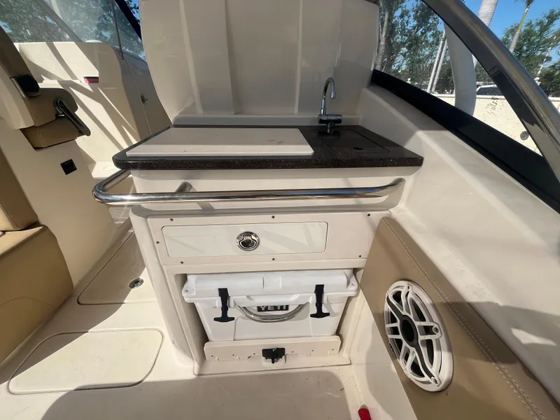 Slide: The Image of 2023 Scout 255 Dorado boat interior with sink, storage, and speaker. - 12