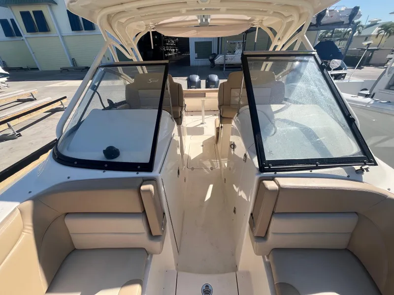 Slide: The Image of 2023 Scout 255 Dorado boat interior with beige seating and dual windshields. - 23