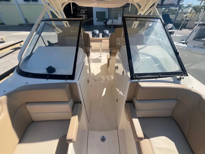 Slide: The Image of 2023 Scout 255 Dorado boat interior with beige seating and dual windshields. - 24