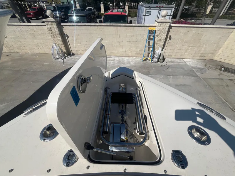 Slide: The Image of 2023 Scout 255 Dorado boat anchor compartment open, showcasing storage and hardware. - 26