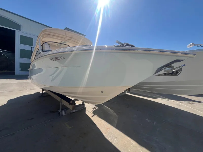 Slide: The Image of 2023 Scout 255 Dorado boat in sunlight, docked outside a building. - 3