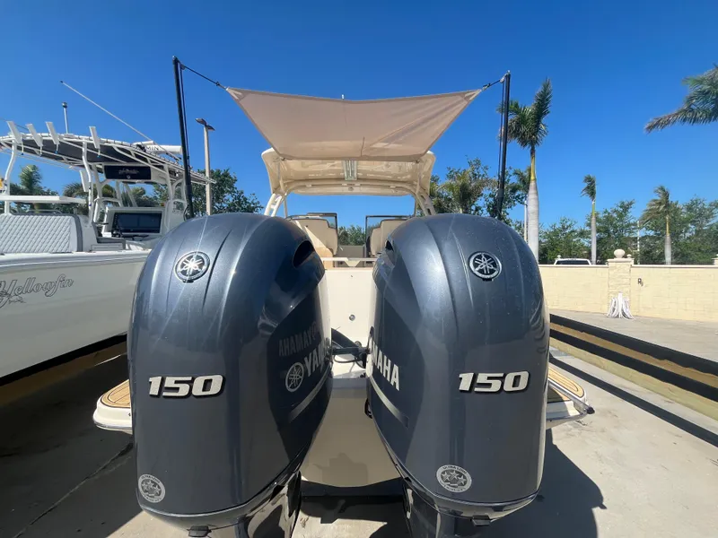 Slide: The Image of 2023 Scout 255 Dorado with twin Yamaha 150 engines, docked under clear blue skies. - 5