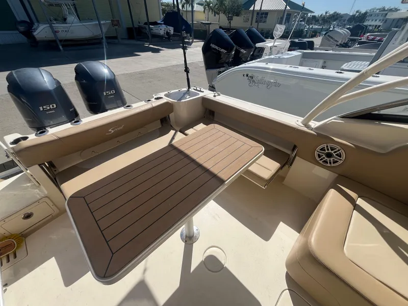 Slide: The Image of 2023 Scout 255 Dorado boat interior with seating and table, featuring twin 150 engines. - 9