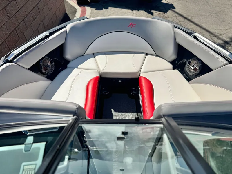 Slide: The Image of 2018 MasterCraft XT22 boat interior with red and white seating, featuring built-in speakers. - 15