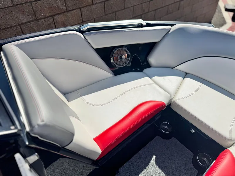 Slide: The Image of 2018 MasterCraft XT22 boat interior with white and red seating, featuring a built-in speaker. - 16