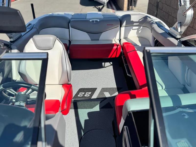 Slide: The Image of 2018 MasterCraft XT22 boat interior with red and gray seating, open cockpit view. - 18