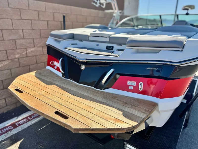 Slide: The Image of 2018 MasterCraft XT22 boat with teak swim platform, red and white design. - 6