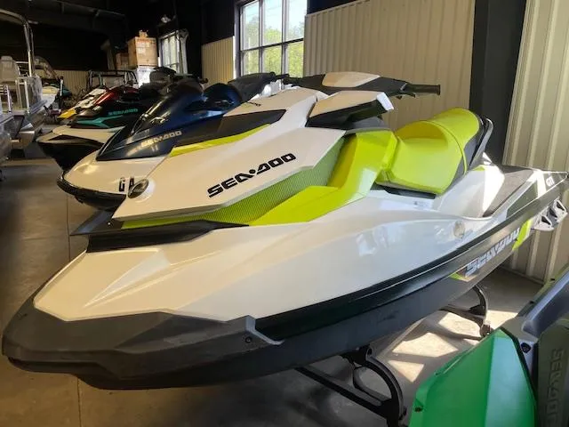 Slide: The Image of 2017 Sea-Doo GTI jet ski with vibrant green and white design in showroom. - 3
