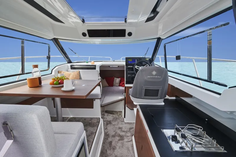 Slide: The Image of Interior of 2025 Jeanneau NC795 S2 boat with modern seating and kitchen area. - 12