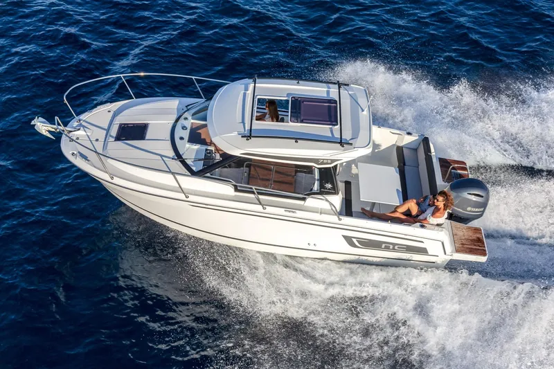 Slide: The Image of 2025 Jeanneau NC795 S2 motorboat cruising on open water, top view. - 3