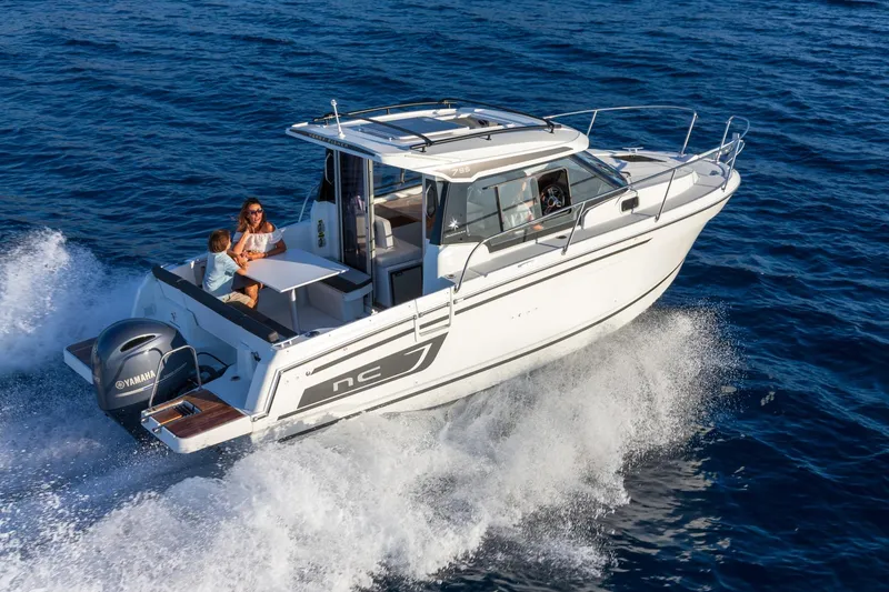Slide: The Image of 2025 Jeanneau NC795 S2 motorboat cruising on open water with passengers enjoying the ride. - 4