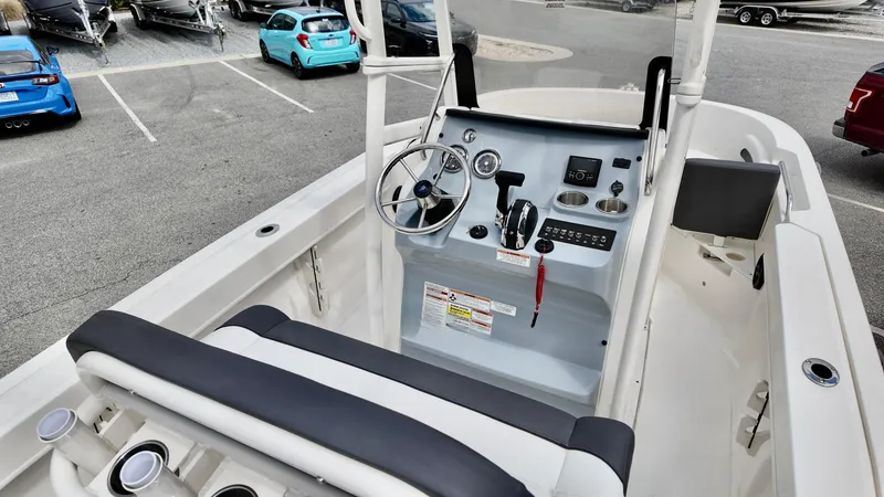 Slide: The Image of 2025 Bayliner Trophy 20 boat interior with steering console and seating in a parking lot. - 14