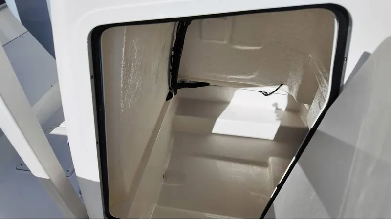 Slide: The Image of 2025 Bayliner Trophy 20 boat storage compartment, open and empty, with white interior. - 9