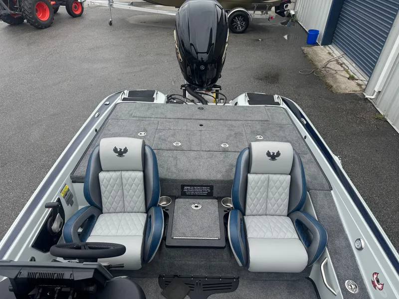 Slide: The Image of 2025 Phoenix 721 ZXL boat interior with dual seats and motor, parked on asphalt. - 10