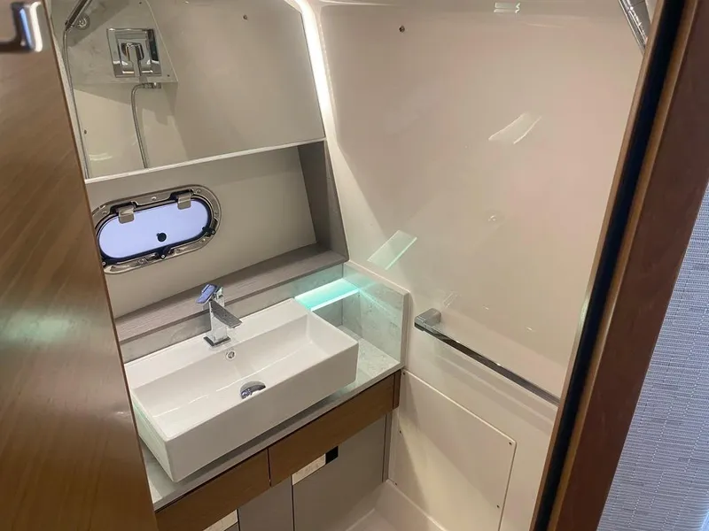 Slide: The Image of 2023 Tiara Sport 38 LS yacht bathroom with modern sink and porthole window. - 16