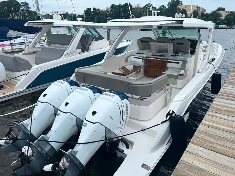 Slide: The Image of 2023 Tiara Sport 38 LS boat docked with triple outboard engines. - 3