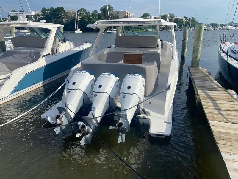 Slide: The Image of 2023 Tiara Sport 38 LS boat with triple outboard engines docked at marina. - 4