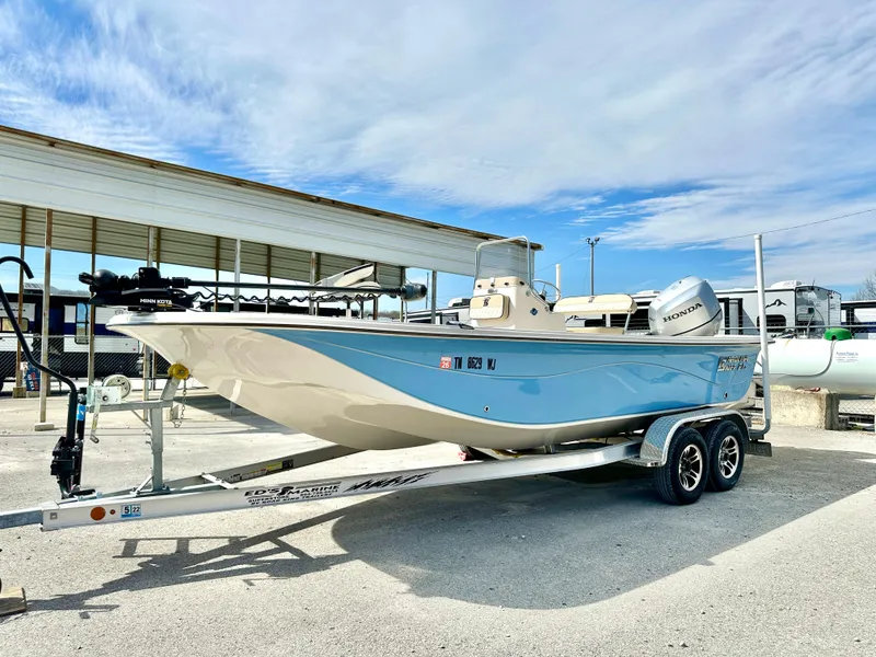Slide: The Image of 2021 Carolina Skiff 21 LS boat on trailer, light blue hull, parked outdoors. - 1