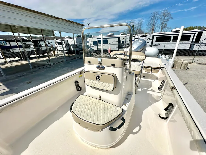Slide: The Image of 2021 Carolina Skiff 21 LS boat interior with seating and console, parked outdoors. - 10