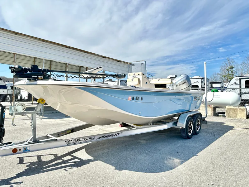 Slide: The Image of 2021 Carolina Skiff 21 LS boat on trailer, parked outdoors under a cloudy sky. - 2