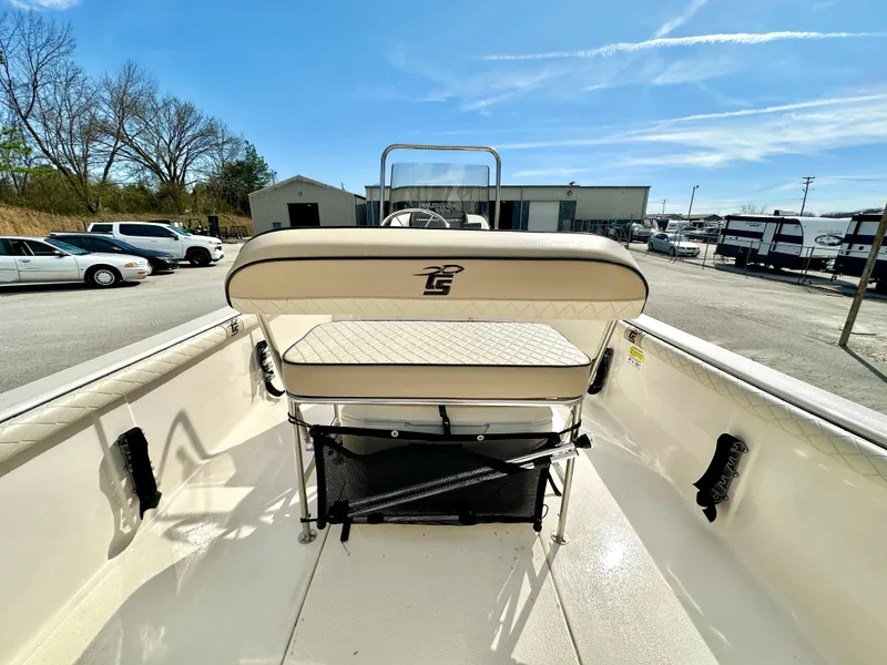 Slide: The Image of 2021 Carolina Skiff 21 LS boat interior with seating and storage, parked outdoors. - 22