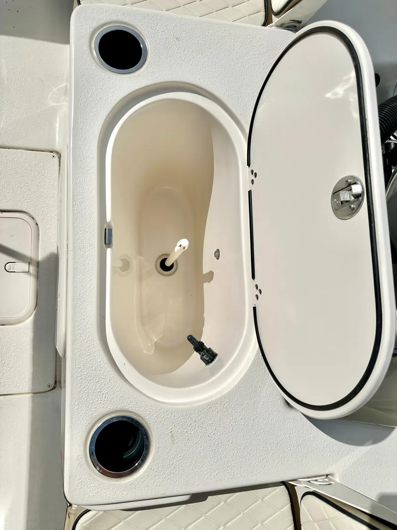 Slide: The Image of Livewell on 2021 Carolina Skiff 21 LS boat, featuring cup holders and a white lid. - 28