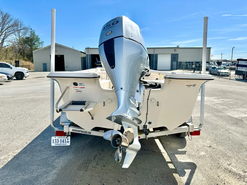Slide: The Image of 2021 Carolina Skiff 21 LS boat with outboard motor on a trailer in a parking lot. - 4