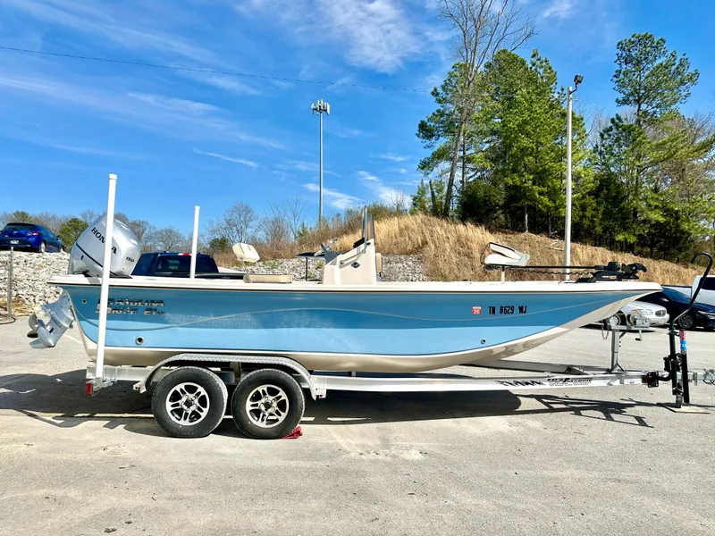 Slide: The Image of 2021 Carolina Skiff 21 LS boat on trailer, parked outdoors under clear blue sky. - 6