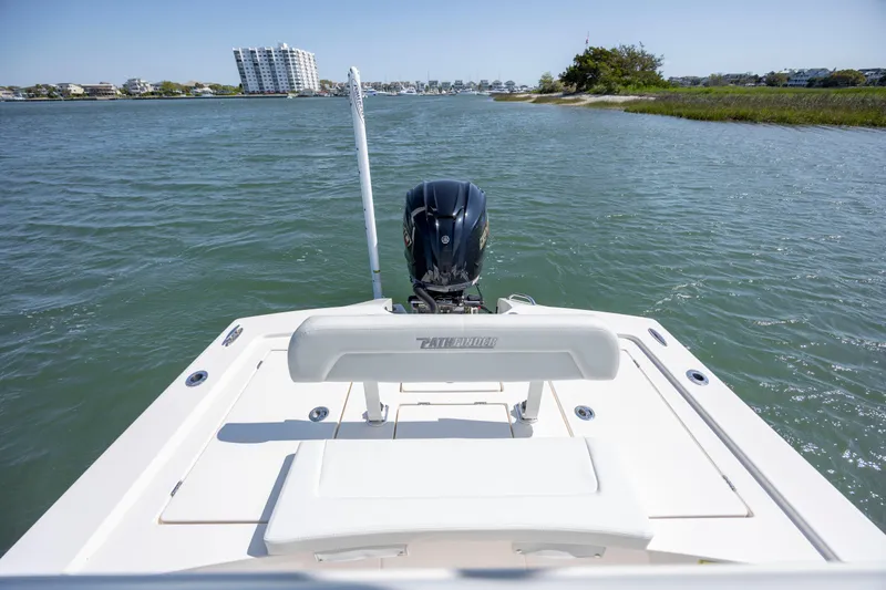 Slide: The Image of 2023 Pathfinder 2300 HPS boat on water, rear view with motor, coastal background. - 20