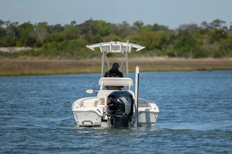 Slide: The Image of 2023 Pathfinder 2300 HPS boat navigating a calm waterway with lush greenery. - 3