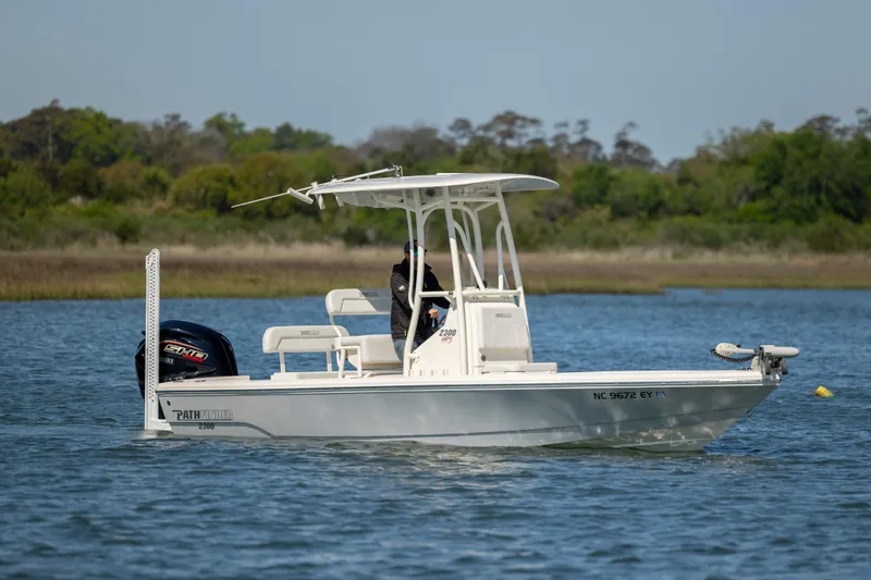 Slide: The Image of 2023 Pathfinder 2300 HPS boat on calm water with trees in the background. - 6