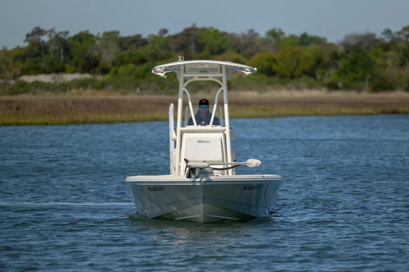 Slide: The Image of 2023 Pathfinder 2300 HPS boat navigating calm waters with lush greenery in the background. - 7