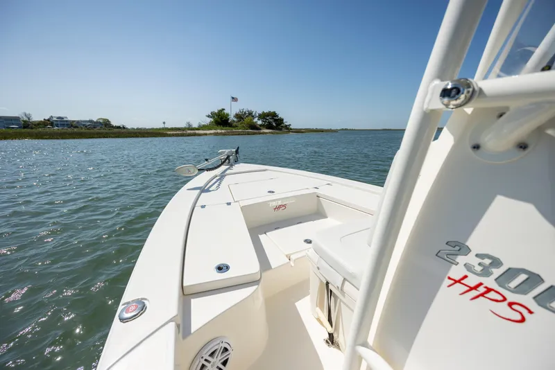 Slide: The Image of 2023 Pathfinder 2300 HPS boat on calm water, showcasing sleek design and open deck. - 9