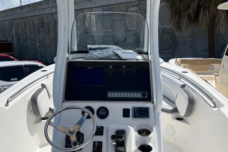 Slide: The Image of 2018 Tidewater 232 CC Adventure boat console with steering wheel and navigation controls. - 10