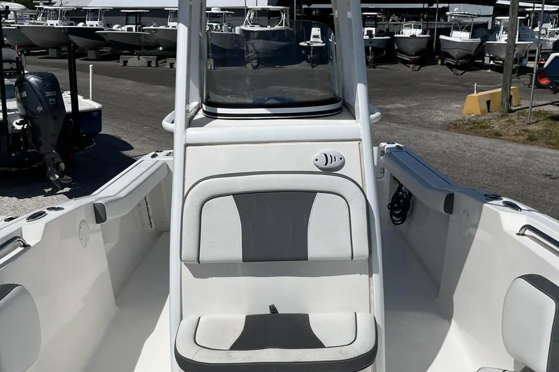 Slide: The Image of 2018 Tidewater 232 CC Adventure boat interior with seating and console, docked in a marina. - 11